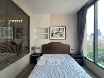 Modern bedroom with large windows offering city views, stylish decor, and natural light.