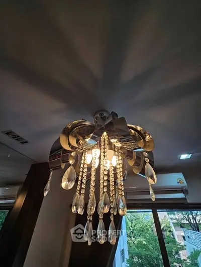 Elegant chandelier with crystal accents in a modern living room setting.