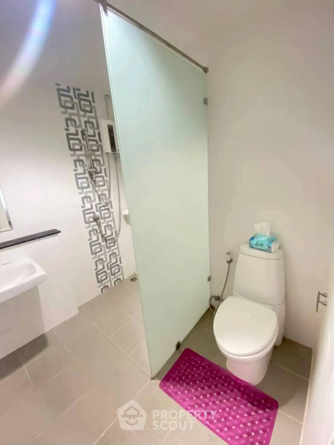 Modern bathroom with frosted glass shower door and stylish tile accent wall.