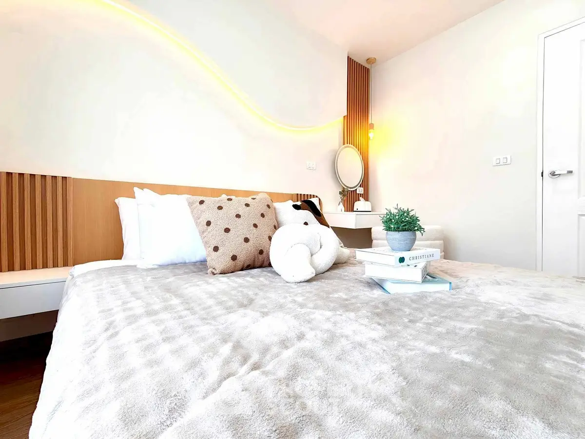 Modern bedroom with cozy decor and soft lighting, featuring a plush bed and stylish accents.