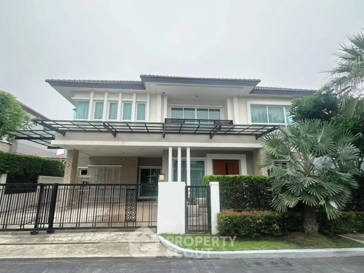 Elegant two-story house with modern facade and lush greenery in a serene neighborhood.