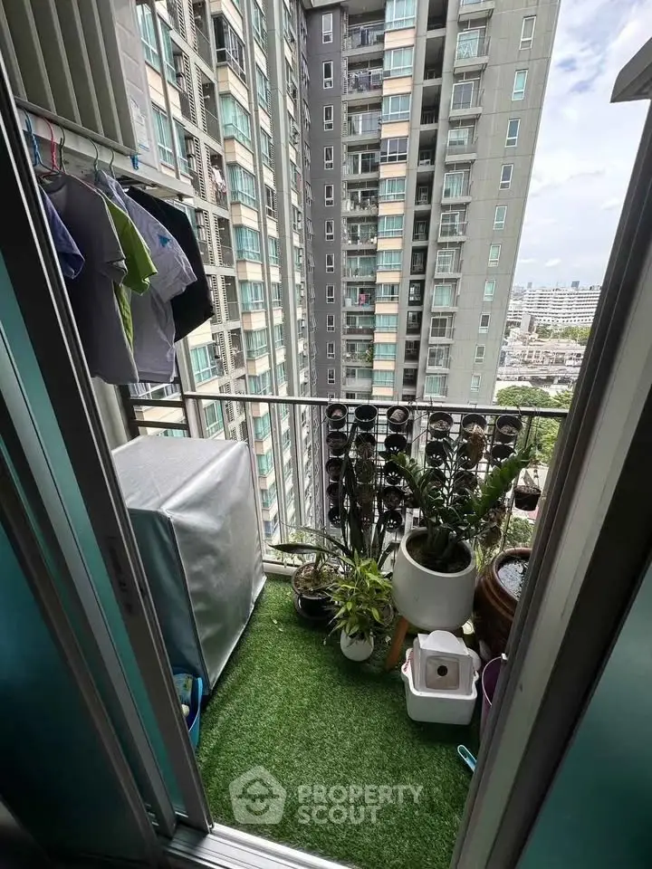 Charming balcony with lush greenery and city view in modern apartment building.