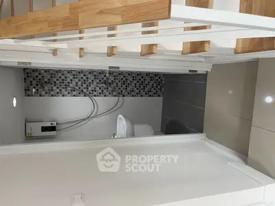 Compact bathroom under staircase with modern design and tiled accents.