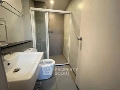 Modern bathroom with sleek shower and contemporary fixtures in a stylish real estate property.