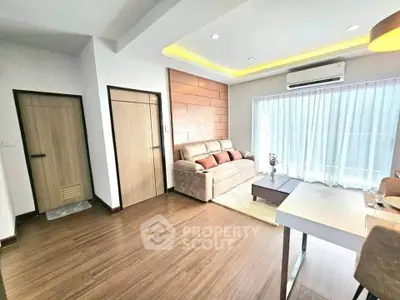 Modern living room with cozy sofa, wooden flooring, and large window for natural light.