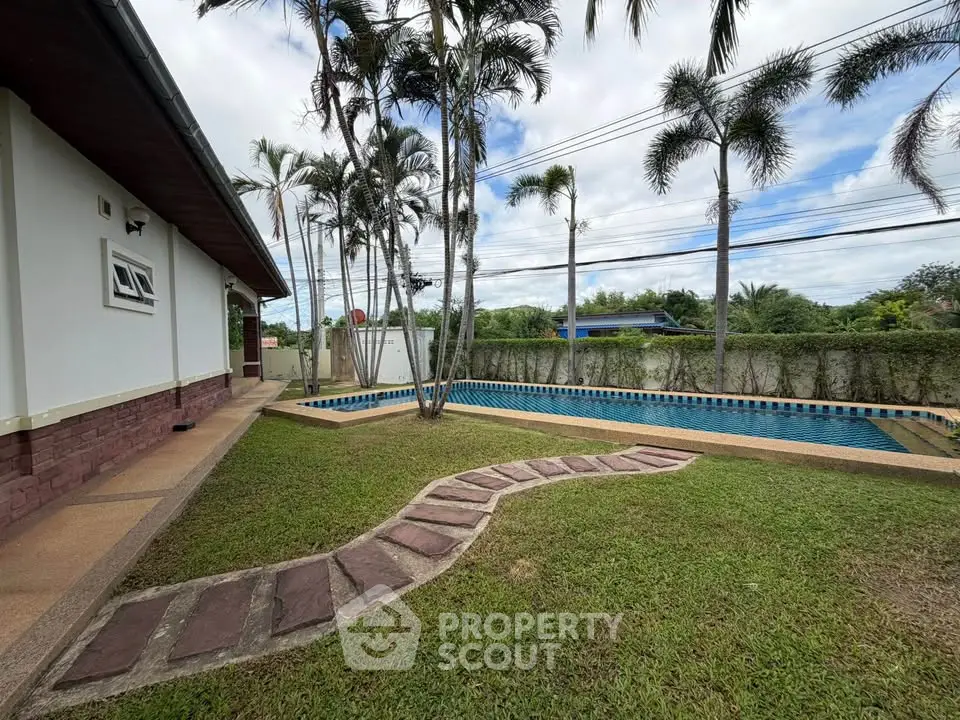 Spacious backyard with private pool and lush greenery, perfect for relaxation and outdoor activities.