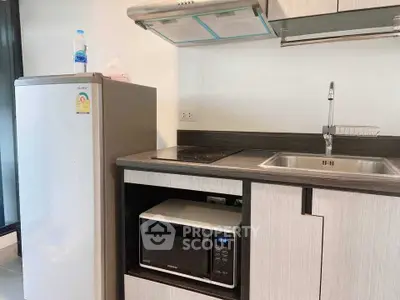 Modern kitchen with sleek appliances and stylish cabinetry in a contemporary apartment.