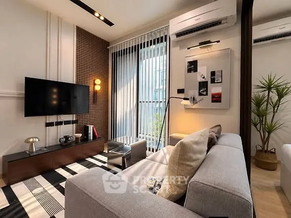 Modern living room with stylish decor, large window, and sleek furniture in a contemporary apartment.