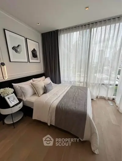 Luxurious bedroom with floor-to-ceiling windows and elegant decor in modern apartment.
