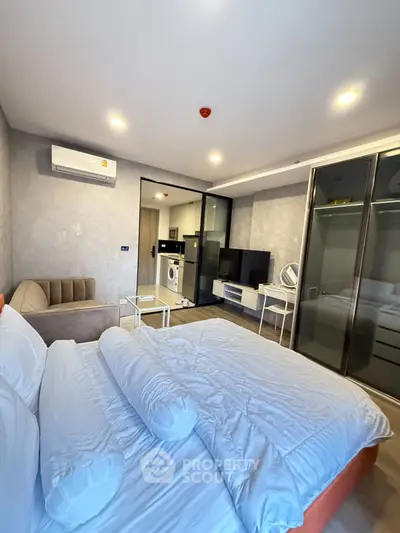 Modern studio apartment with cozy bed and in-unit washing machine