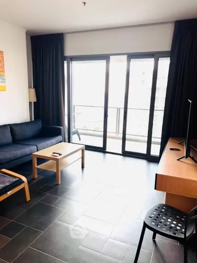 Modern living room with balcony view, sleek furniture, and natural light.