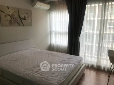 Bright and cozy bedroom with large windows and modern decor in a stylish apartment.