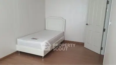 Minimalist bedroom with single bed and wooden flooring