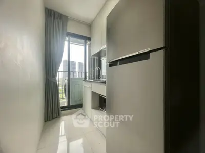 Modern kitchen with sleek appliances and balcony view in urban apartment