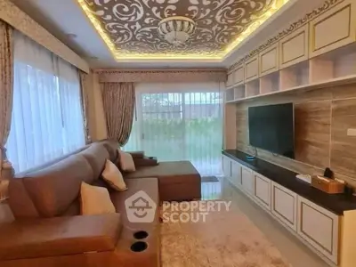 Luxurious living room with elegant ceiling design and modern entertainment setup.