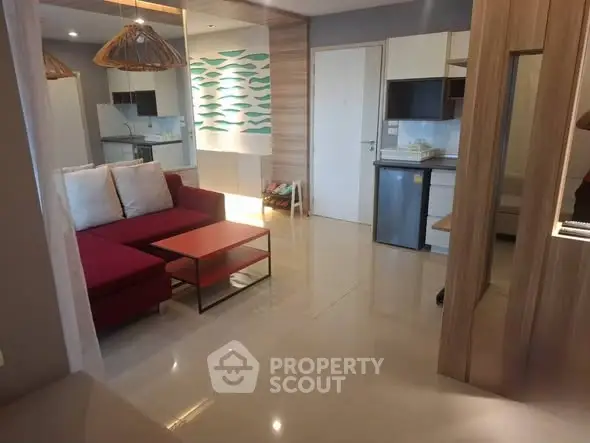 Modern open-layout living room with stylish decor and compact kitchen area.