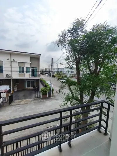 Charming balcony view of modern residential neighborhood with lush greenery.