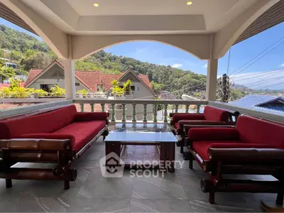 Charming balcony with red cushioned seating and scenic mountain views, perfect for relaxation and entertaining.