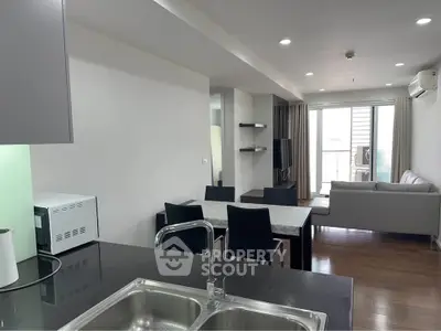 Modern open-plan living room with dining area and sleek kitchen design.