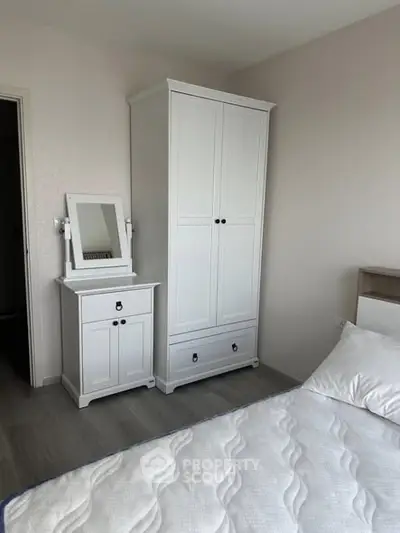 Cozy bedroom with white furniture and comfortable bed in modern apartment.