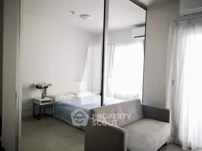 Modern bedroom with mirrored closet and cozy seating area