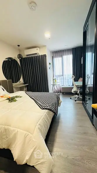 Modern bedroom with stylish decor and natural light, featuring a cozy workspace and elegant furnishings.