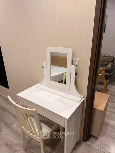 Cozy bedroom corner with elegant white vanity and chair, perfect for a serene morning routine.