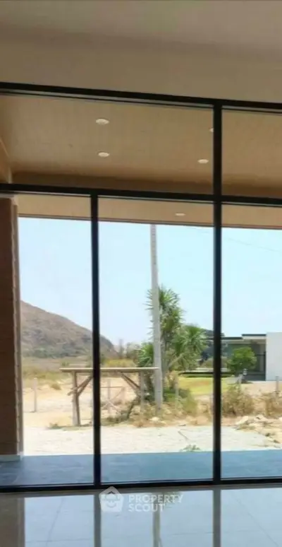 Spacious modern interior with large glass doors offering stunning outdoor views.