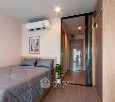 Modern bedroom with stylish decor and sliding glass door leading to hallway.