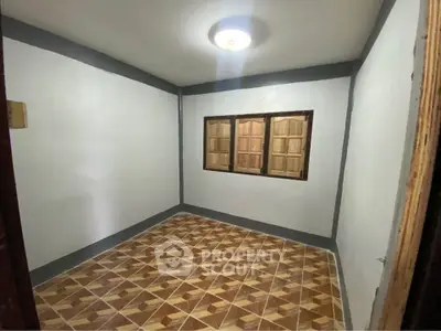 Cozy room with tiled flooring and wooden window shutters, perfect for a small bedroom or study.