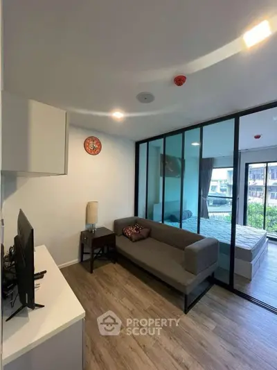 Modern living room with glass partition and cozy decor in urban apartment