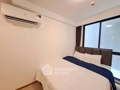 Cozy bedroom with air conditioning and large window for natural light.