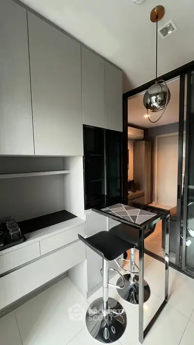 Modern kitchen with sleek cabinetry and stylish bar seating in a contemporary apartment.