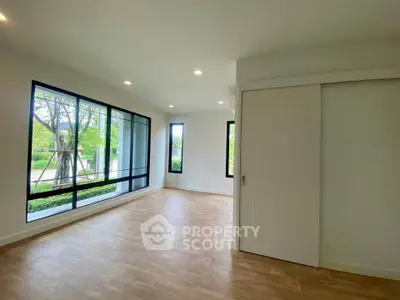 Spacious modern living room with large windows and wooden flooring