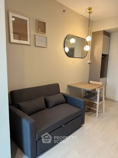 Modern living room with stylish sofa, wall art, and chic lighting in a cozy apartment.