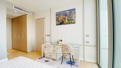 Modern bedroom with study area and large window offering natural light.
