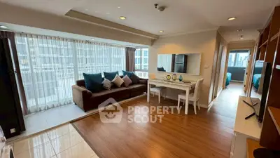 Spacious living room with large windows and modern decor in a high-rise apartment.
