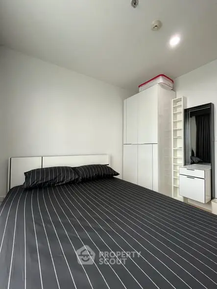 Modern minimalist bedroom with sleek black and white decor, featuring a stylish wardrobe and vanity.