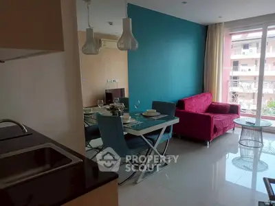 Modern living room with vibrant decor and dining area, featuring a stylish red sofa and elegant lighting.