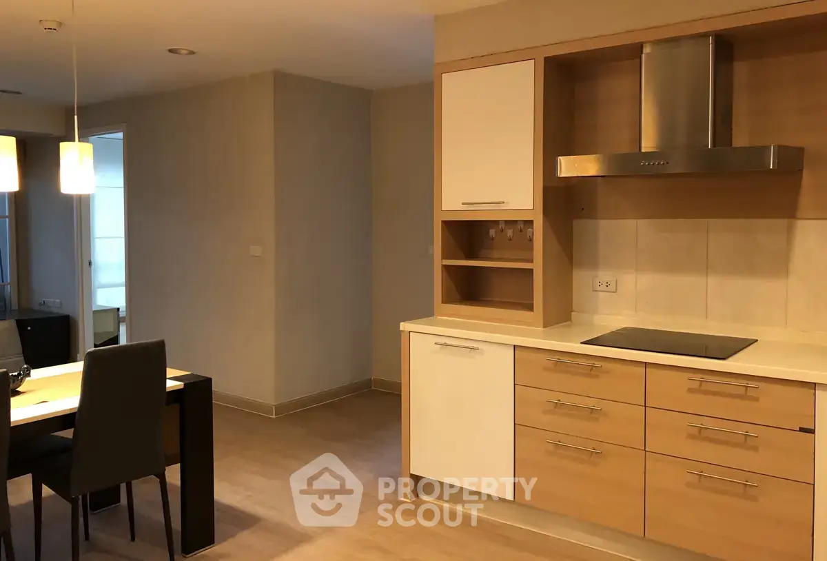 Modern kitchen with sleek cabinetry and dining area in open layout apartment.