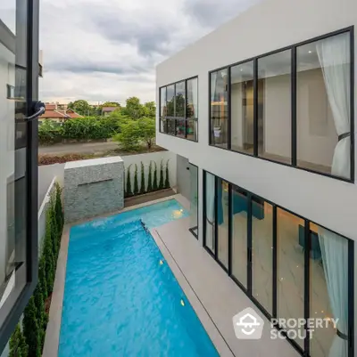 Modern luxury home with private pool and large windows offering stunning views.