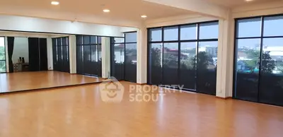 Spacious room with large mirrors and floor-to-ceiling windows, ideal for dance or yoga studio.