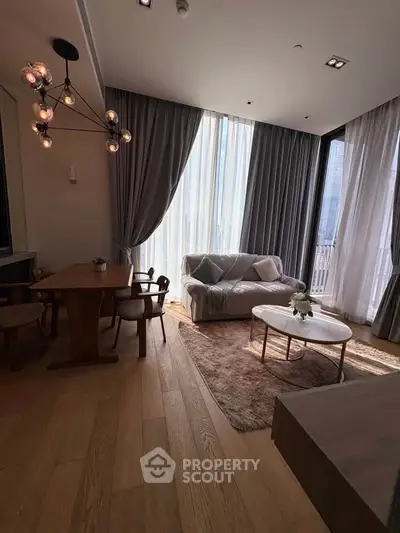 Elegant living room with modern furniture and large windows offering natural light.