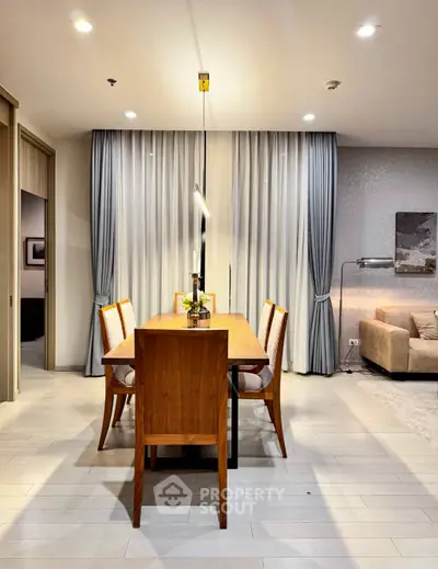 Elegant dining area with modern wooden table and chairs, complemented by stylish curtains and ambient lighting.