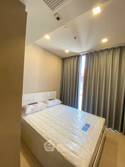Modern bedroom with large window and stylish curtains in a cozy apartment.