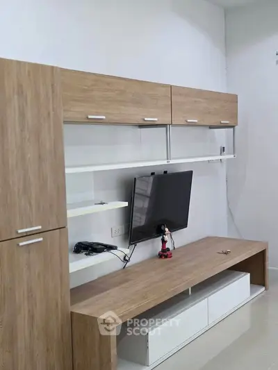 Modern living room with sleek wooden entertainment unit and mounted TV