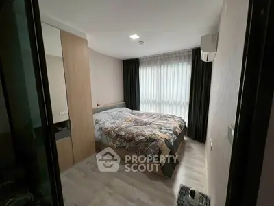 Cozy bedroom with modern decor and large window for natural light