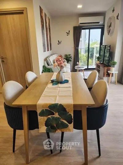 Modern living room with dining area, stylish decor, and balcony view in a cozy apartment.