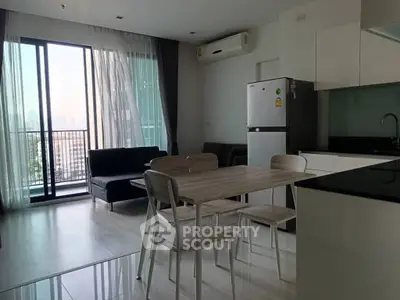 Modern open-plan living room with balcony and sleek kitchen design