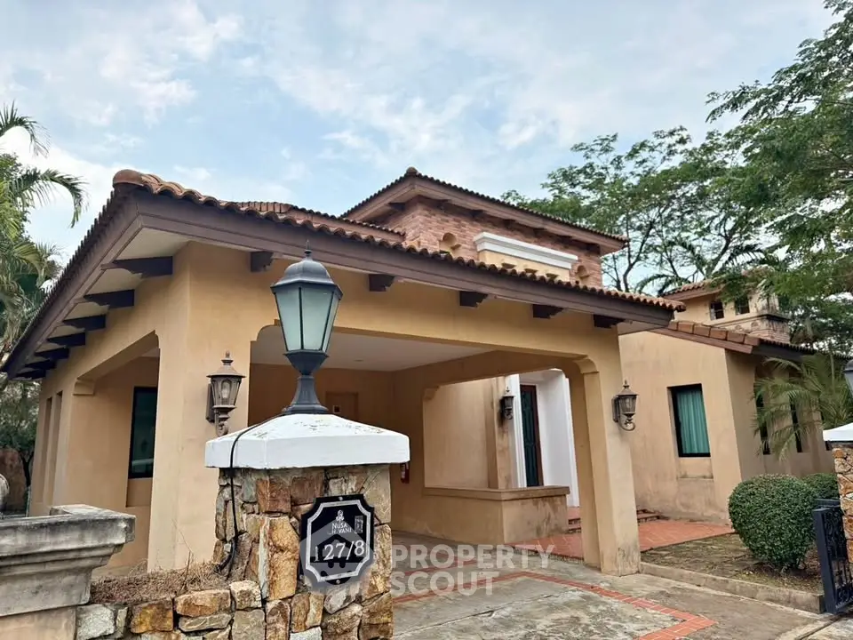 Charming Mediterranean-style home with spacious driveway and lush greenery, perfect for family living.